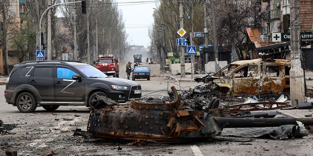 A part of a destroyed tank and a burned vehicle sit in an area controlled by Russian-backed separatist forces in Mariupol, Ukraine, Saturday, April 23, 2022. 
