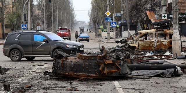 A part of a destroyed tank and a burned vehicle sit in an area controlled by Russian-backed separatist forces in Mariupol, Ukraine, Saturday, April 23, 2022. 