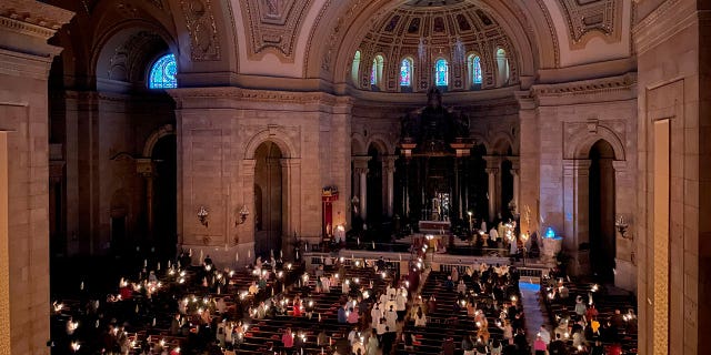 Hundreds of people light candles at the beginning of the Easter Vigil Mass at the Cathedral of St. Paul in St. Paul, Minnesota, on Saturday, April 16, 2022.