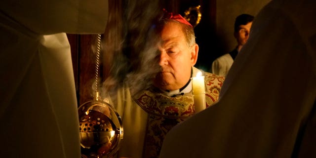 Archbishop Bernard Hebda lights a censer while blessing the fire and the Paschal candle ceremony at the Cathedral of St. Paul in St. Paul, Minn., April 16, 2022.