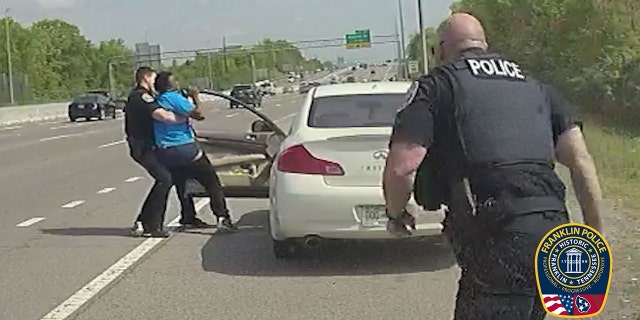 Nicholson attempts to get back into his car as Officer Matt Lamarr rushes to assist Stevens.