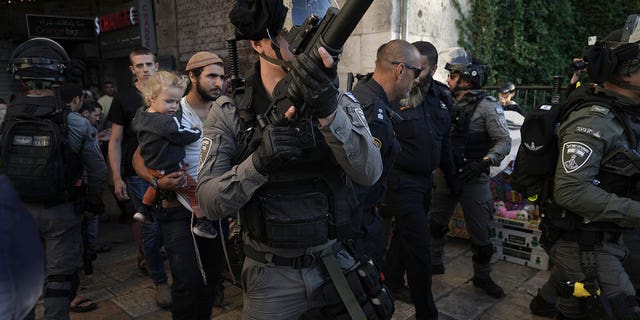 Israeli security forces escort a group of Jews outside Damascus Gate, in Jerusalem's Old City, Wednesday, April 20, 2022. Police prevented hundreds of ultra-nationalist Israelis from marching around predominantly Palestinian areas of Jerusalem's Old City. The event planned for Wednesday was similar to one that served as one of the triggers of last year's Israel-Gaza war. (AP Photo/Mahmoud Illean)