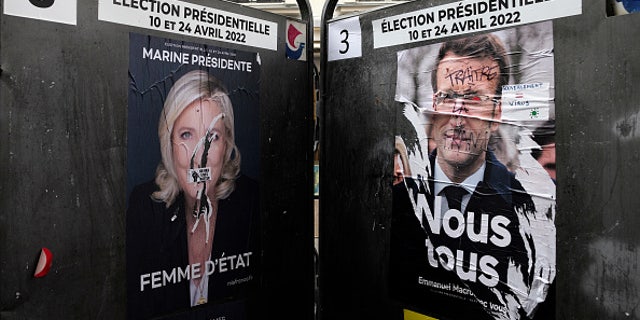 Campaign posters displayed on billboards next to a polling station April 4, 2022, in Paris.