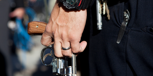 A San Diego police officer carries a Smith and Wesson revolver during a gun buy-back Dec. 21, 2012 in San Diego.