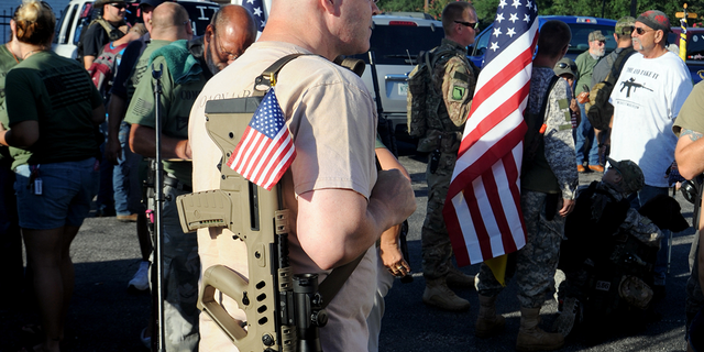 With loaded firearms in hand and flags all around, people gather for a 5-Mile Open Carry March for Freedom organized by Florida Gun Supply in Inverness, Fla. July 4, 2016. 