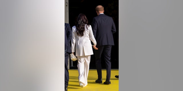 Prince Harry and Meghan Markle, Duke and Duchess of Sussex, hold hands as they arrive at the Invictus Games.