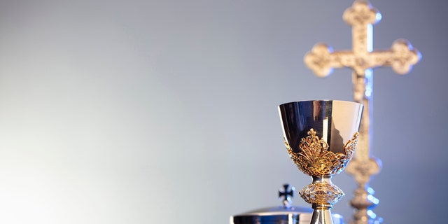 A Cross, monstrance and golden chalice. 