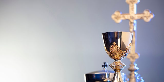 A Cross, monstrance and golden chalice.