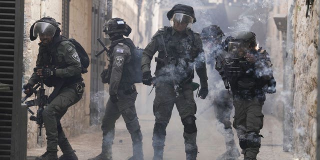 Palestinians shoot fireworks at Israeli police in the Old City of Jerusalem, Sunday, April 17, 2022. Israeli police clashed with Palestinians outside Al-Aqsa Mosque after police cleared the compound to facilitate the routine visit of Jews to the holy site. 