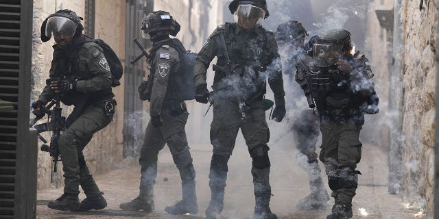 Palestinians shoot fireworks at Israeli police in the Old City of Jerusalem, Sunday, April 17, 2022. Israeli police clashed with Palestinians outside the Al-Aqsa Mosque after police cleared Palestinians from the sprawling compound to facilitate a routine Jewish visit to the holy site, accusing Palestinians of piling stones in anticipation of violence.
