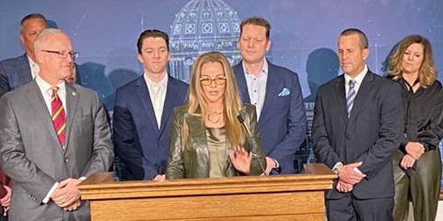 April 6 has been declared Vince Flynn Day in Minnesota. State Rep. Jim Nash is at far left; Vince Flynn's wife, Lysa Flynn, is shown making remarks at the ceremony. Vince Flynn's brother, Tim Flynn, made remarks as well. 