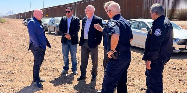 Sen.  Mark Kelly talks with CBP personnel at the border in Douglas, Arizona.