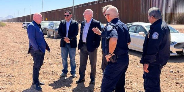 Sen. Mark Kelly talks with CBP personnel at the border in Douglas, Arizona.