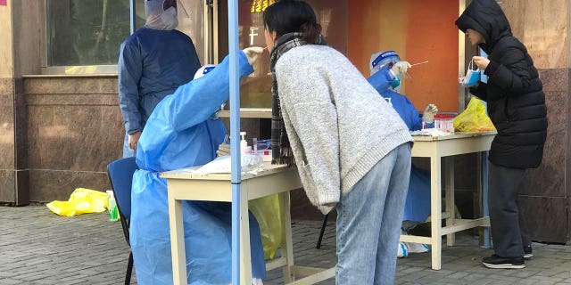 Medical workers conduct mass testing for residents in a lockdown area in the Jingan district of western Shanghai