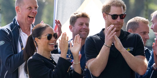 Prince Harry and Meghan Markle cheer from the sidelines as they attend the Land Rover Driving Challenge at the Invictus Games.
