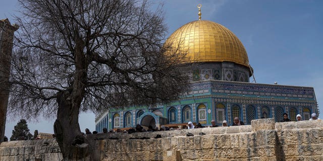 Muslim worshippers gather for Friday prayers, next to the Dome of the Rock Mosque in the Al Aqsa Mosque compound in Jerusalem's old city, Friday, April 1, 2022. 