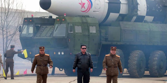 Sjevernokorejski vođa Kim Jong Un, u sredini, obilazi interkontinentalni balistički projektil Hwasong-17 na lanseru na neobjavljenoj lokaciji u Sjevernoj Koreji.