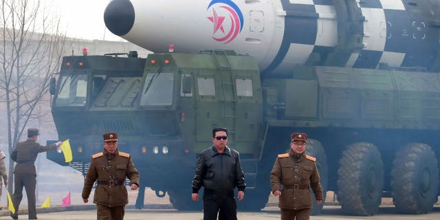 North Korean leader Kim Jong Un, center, walks around a Hwasong-17 intercontinental ballistic missile on the launcher at an undisclosed location in North Korea.