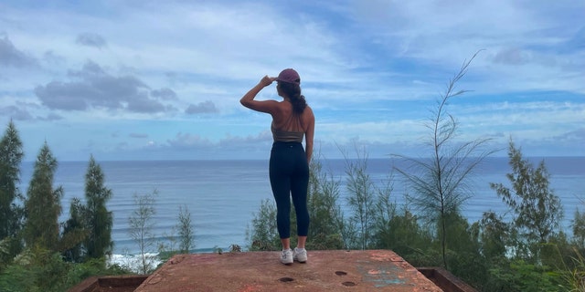 A traveler stands atop the remains of a WWII pillbox bunker while on a hike on the island of Oahu, Hawaii, March 29, 2022. (Danielle Pellini)