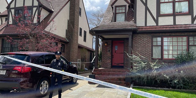 A police officer stands at Orsolya Gaal's family home in Queens as law enforement investigates her brutal death on Saturday. (Fox News Digital)