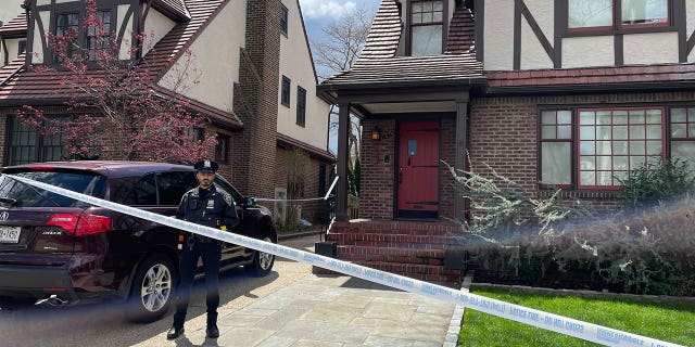 A police officer stands at Orsolya Gaal's family home in Queens as law enforement investigates her brutal death on Saturday. (Fox News Digital)