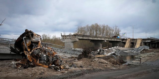 A destroyed car and bridge in the village of Dymer, in Kyiv region, Ukraine, Tuesday, April 12, 2022.