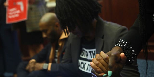 Rep. Angie Nixon, D-Jacksonville, holds hands with Rep. Felicia Robinson, D-Miami Gardens, as debate stops for a protest on Senate Bill 2-C: Establishing the Congressional Districts of the State in the House of Representatives on Thursday, April 21, 2022.
