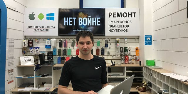 2022年3月16日，一家维修苹果设备的商店的负责人马拉特·格拉切夫（Marat Grachev）在莫斯科用俄语摆姿势，上面写着“对战争说不”。