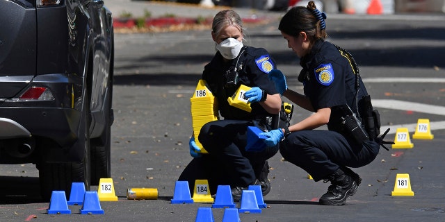 Sacramento Police crime scene investigators place evidence markers on 10th street at the scene of a mass shooting in Sacramento, Calif., on Sunday, April 3, 2022.