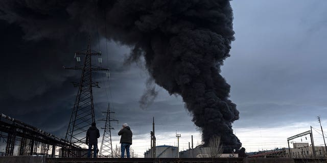 People watch as smoke rises in the air after shelling in Odesa, Ukraine, Sunday, April 3, 2022.