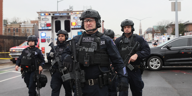 Law enforcement officers work near the scene of a shooting at a subway station in the Brooklyn, April 12, 2022.