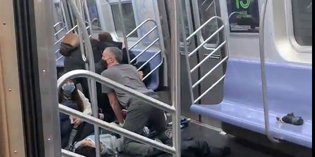 A person is aided in a subway car in Brooklyn, New York, Tuesday, April 12, 2022.