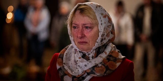 Olga Zhovtobrukh, 55, cries during an Easter service celebrated at a church in Bucha on the outskirts of Kyiv, Sunday, April 24, 2022. 