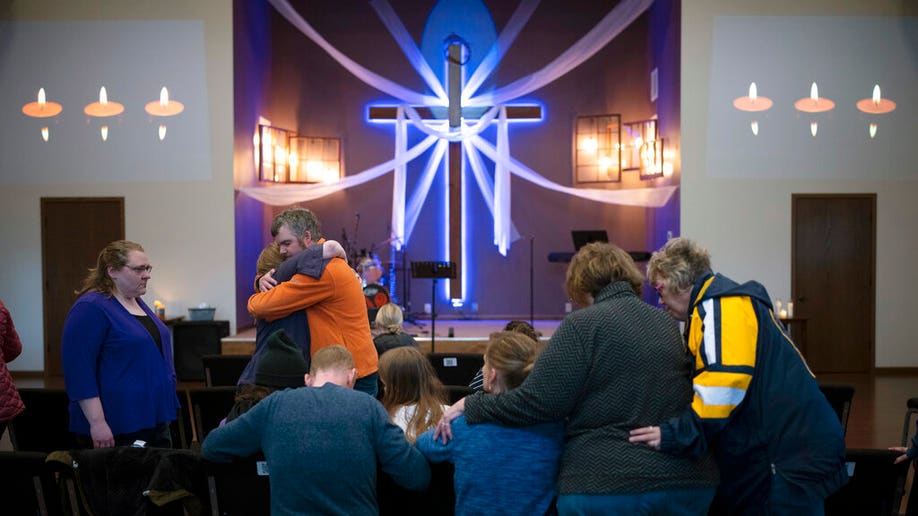 Relatives of Iliana "Lily" Peters comfort each other as they pray together at a vigil for the 10 year-old girl at Valley Vineyard Church in Chippewa Falls, Wis., Monday evening, April 25, 2022. Peters was found dead in a park earlier in the day after being reported missing the night before.