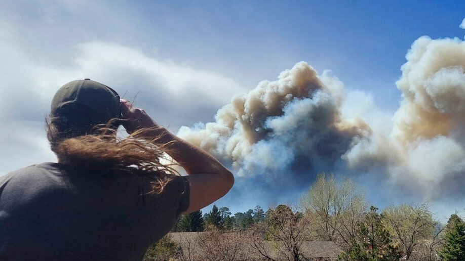 A woman looks at smoke from a wildfire in Flagstaff