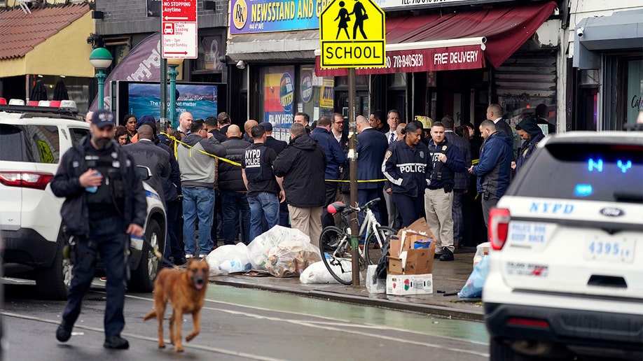 New York City Police Department personnel gather at the entrance to a subway stop in the Brooklyn borough of New York, Tuesday, April 12, 2022. (AP Photo/John Minchillo)