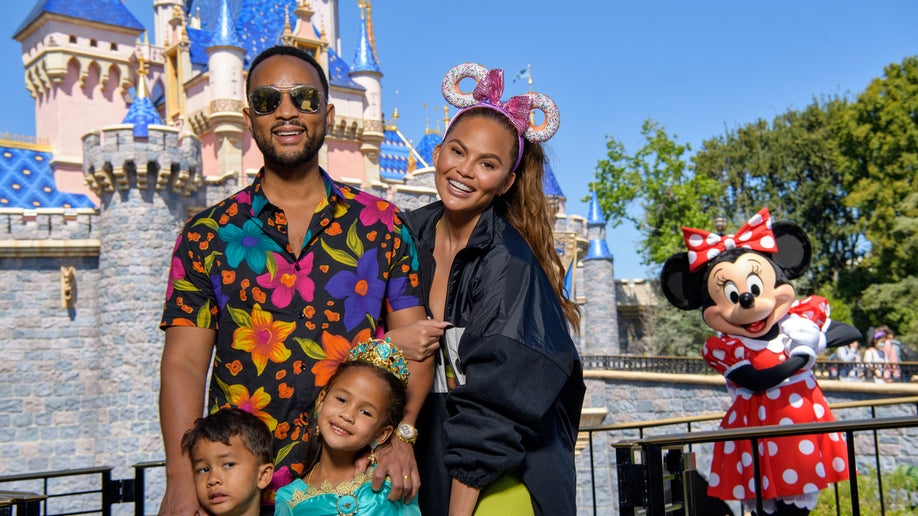 In this handout photo provided by Disneyland Resort, John Legend, Chrissy Teigen and their children, Miles and Luna pose with Minnie Mouse while celebrating Luna’s birthday 