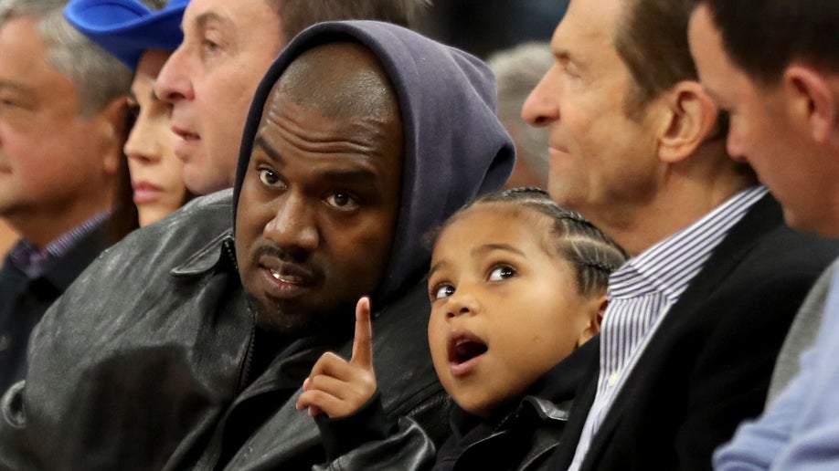 Kanye West, center, and his son, Saint West, got front row seats next to Golden State Warriors co-owners Joe Lacob and Peter Guber as they watch the game against the Boston Celtics 