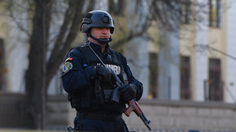 A Romanian serviceman stands next to the Russian embassy in Romania.