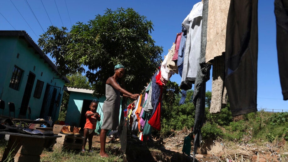 A woman and her son hang wet clothes in Durban