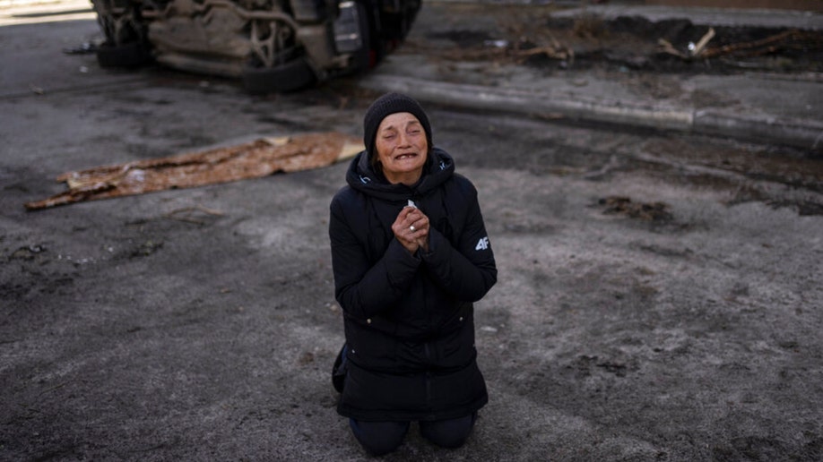 A Ukrainian woman mourns the death of her husband in Bucha.