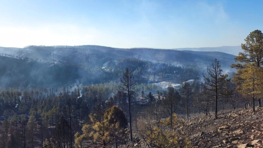 Smoke from a wildfire rises along a New Mexico hillside