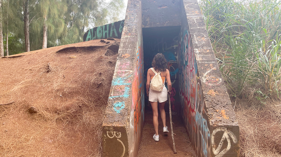 Female traveler explores WWII pillbox bunker in Oahu, HI
