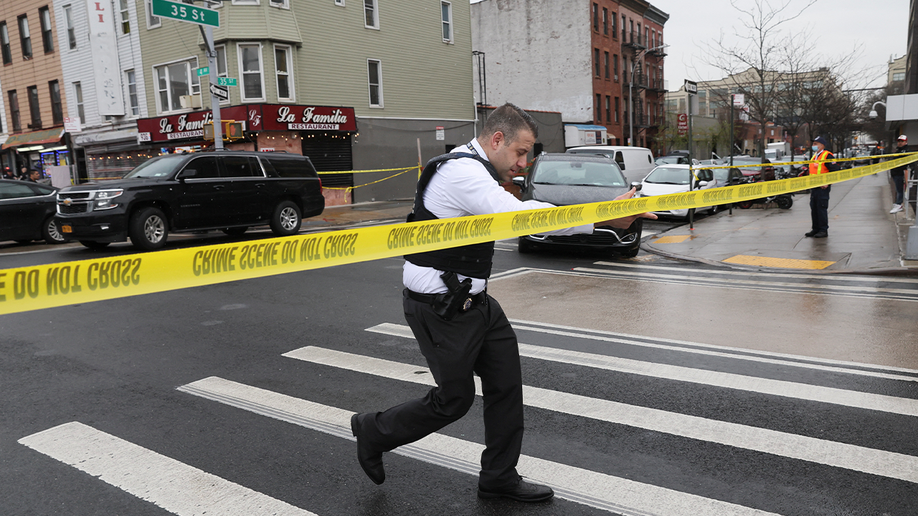 Law enforcement officers work near the scene of a shooting at a subway station in the Brooklyn borough of New York City, New York, U.S., April 12, 2022