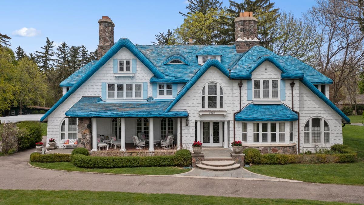 An upfront view of the blue Costwold-style house in the Pine Lake area of West Bloomfield Township, Michigan.