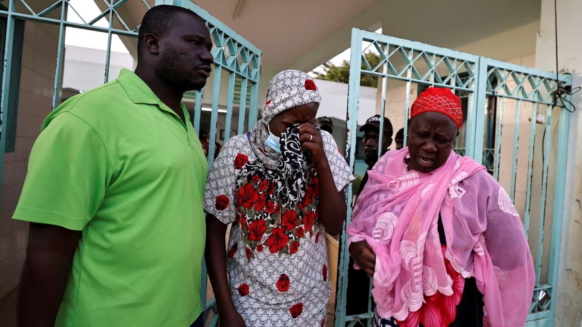 Diali Kaba walks through a gated area of Mame Abdou Aziz Sy Dabakh hospital and cries after receiving grave news