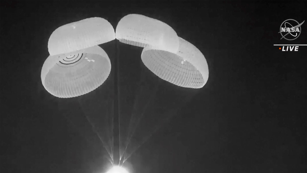 In this image made from video supplied by NASA, SpaceX Dragon capsule uses parachutes as it descends in the Gulf of Mexico early Friday, May 6, 2022. NASA’s Raja Chari, Tom Marshburn and Kayla Barron, and the European Space Agency’s Matthias Maurer undocked from the International Space Station less than 24 hours earlier. (NASA via AP)