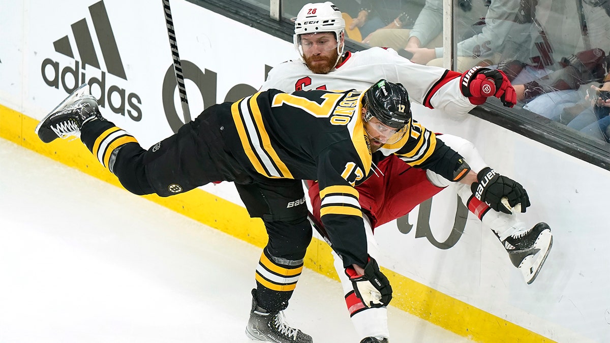 Boston Bruins' Nick Foligno, front, collides with Carolina Hurricanes' Ian Cole, behind, in the first period of Game 4 of an NHL hockey Stanley Cup first-round playoff series, Sunday, May 8, 2022, in Boston. 
