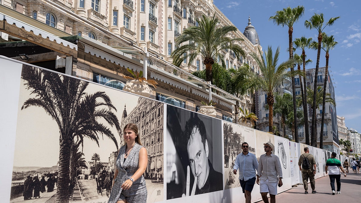People walk along the Croisette prior to the 75th international film festival, Cannes, southern France, Monday, May 16, 2022.The Cannes film festival runs from May 17th until May 28th 2022. (AP Photo/Petros Giannakouris)