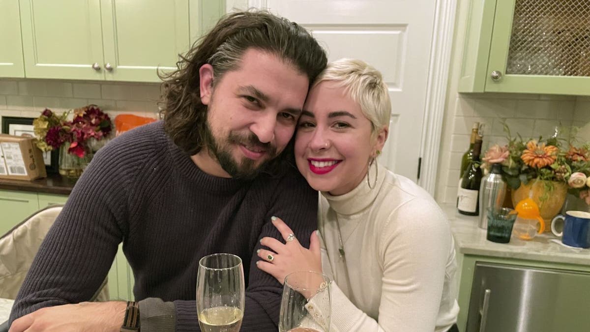 Quinn Alvarez and Lena Kazer pose in kitchen with drinks visible on tabletop